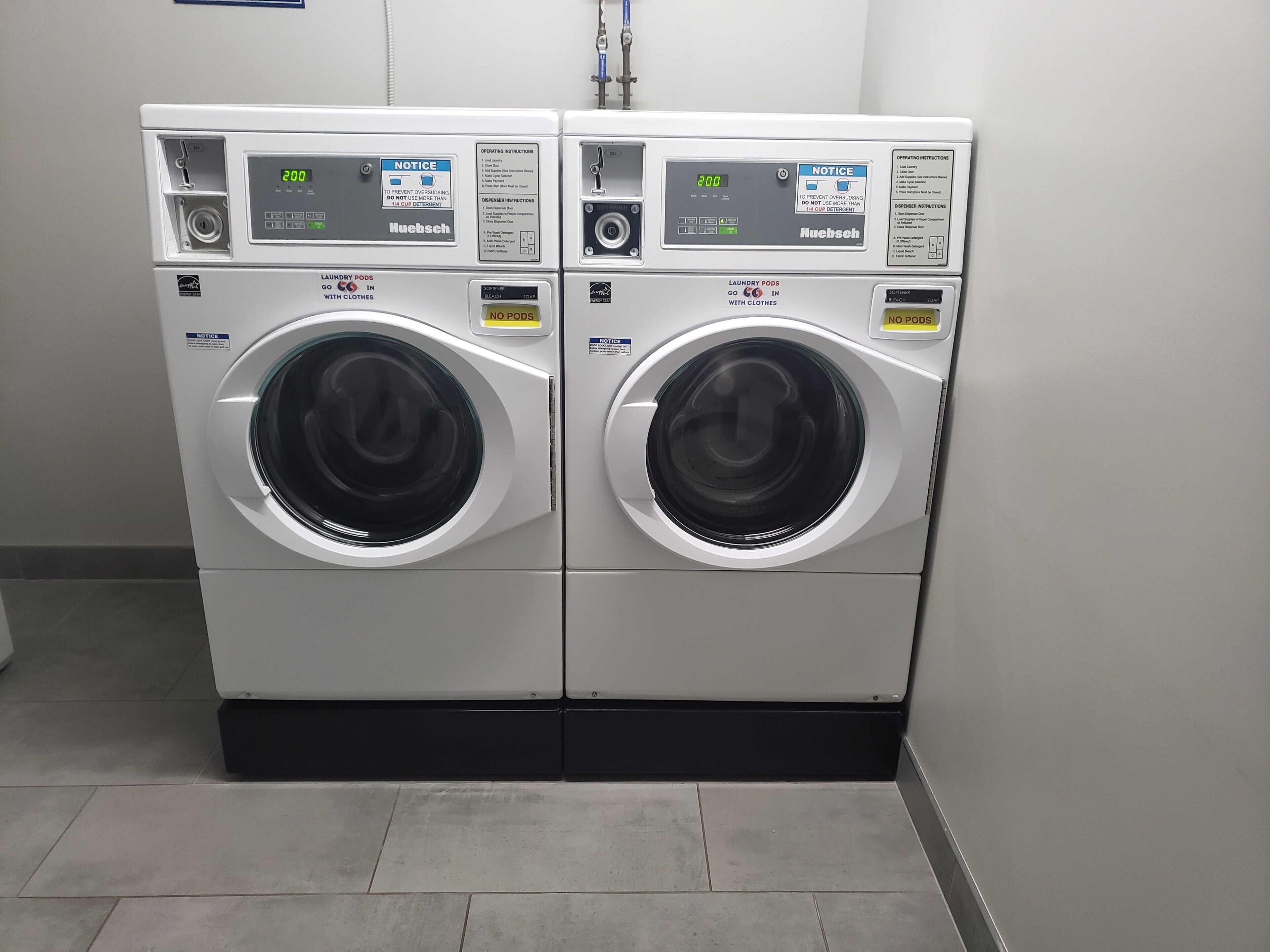 Two front-loading washing machines in a commercial setting.