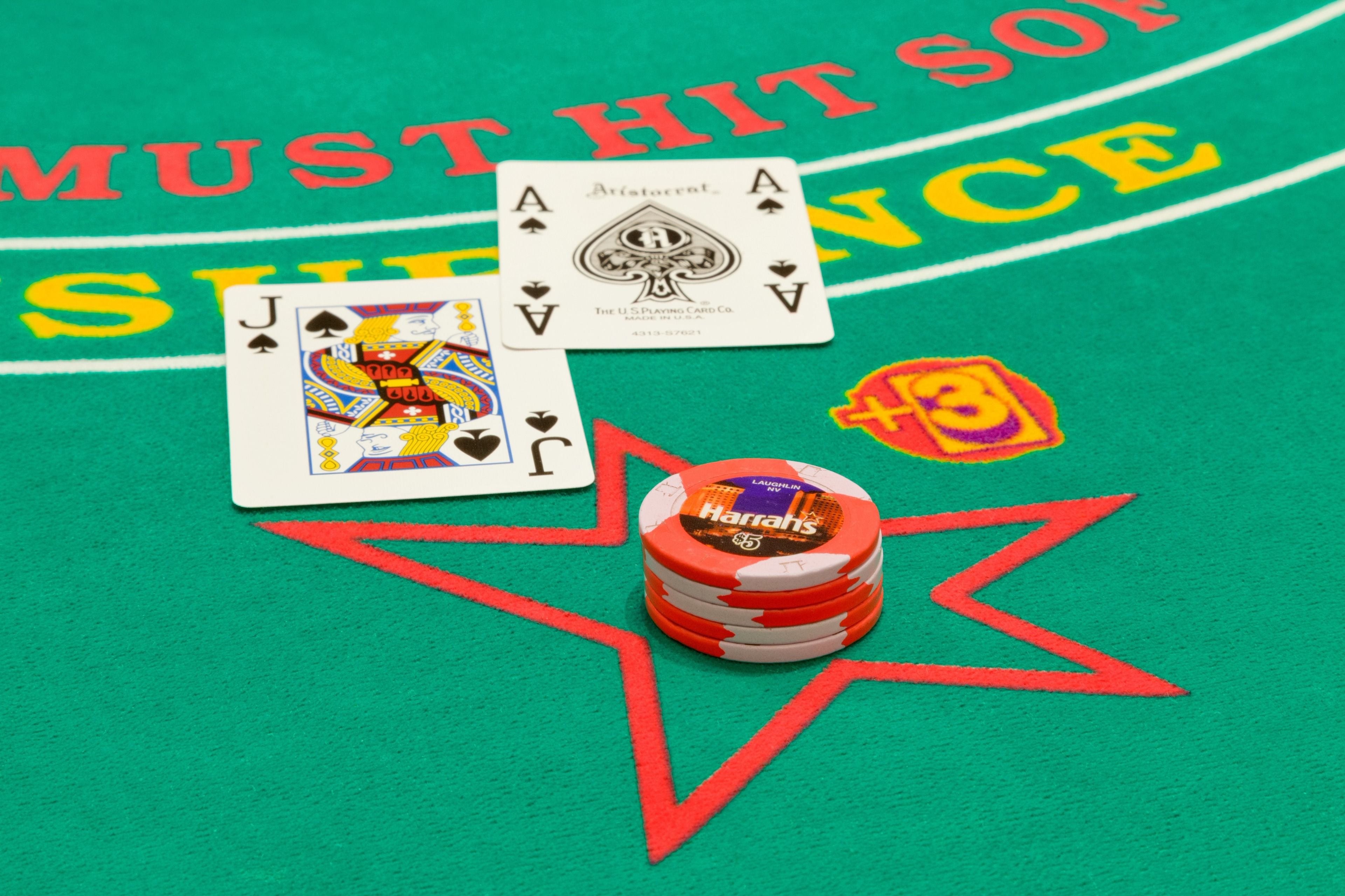 A green felt table with poker chips, playing cards, and a star-shaped design.