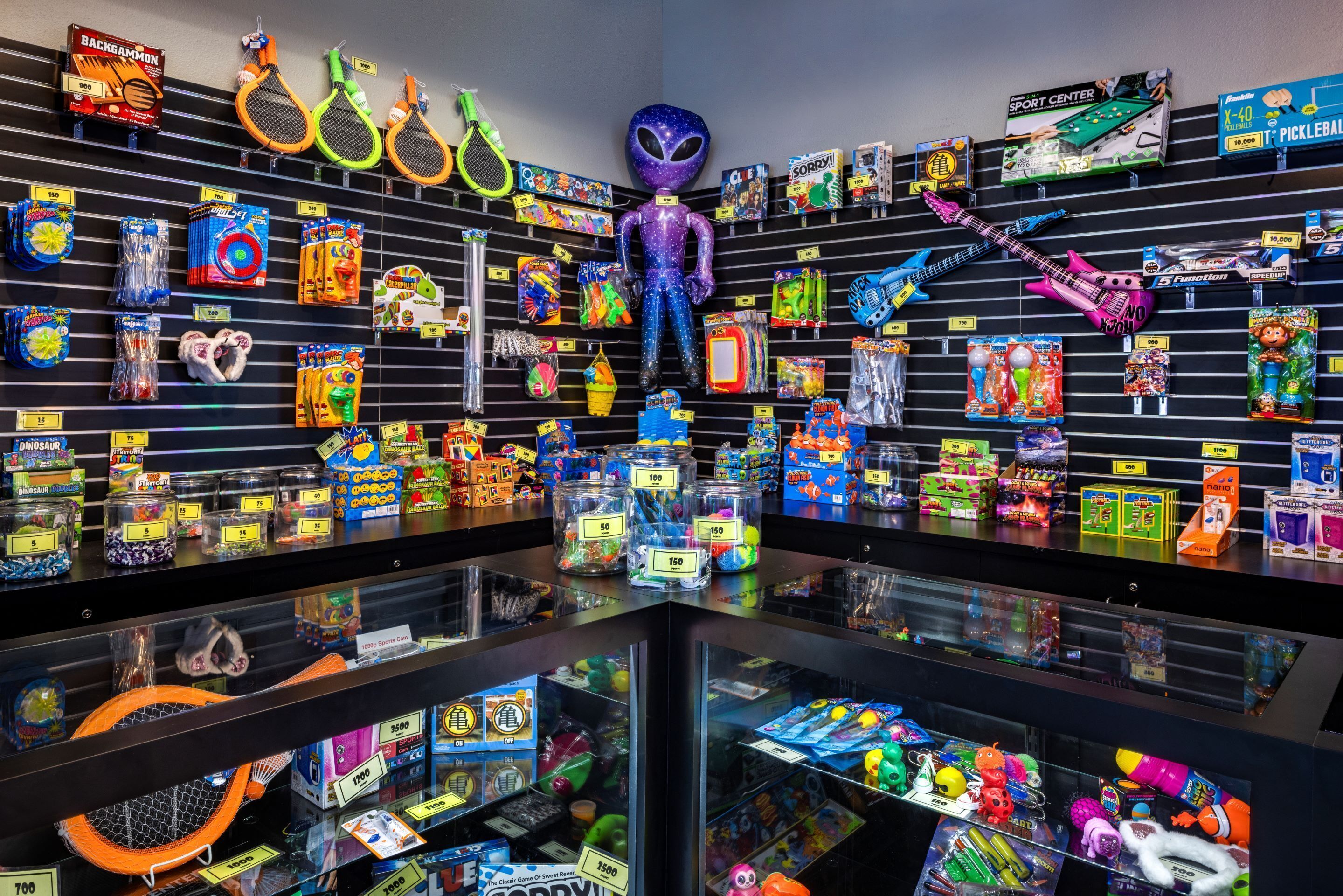 A store with shelves stocked with toys, including action figures, sports equipment, and various games.