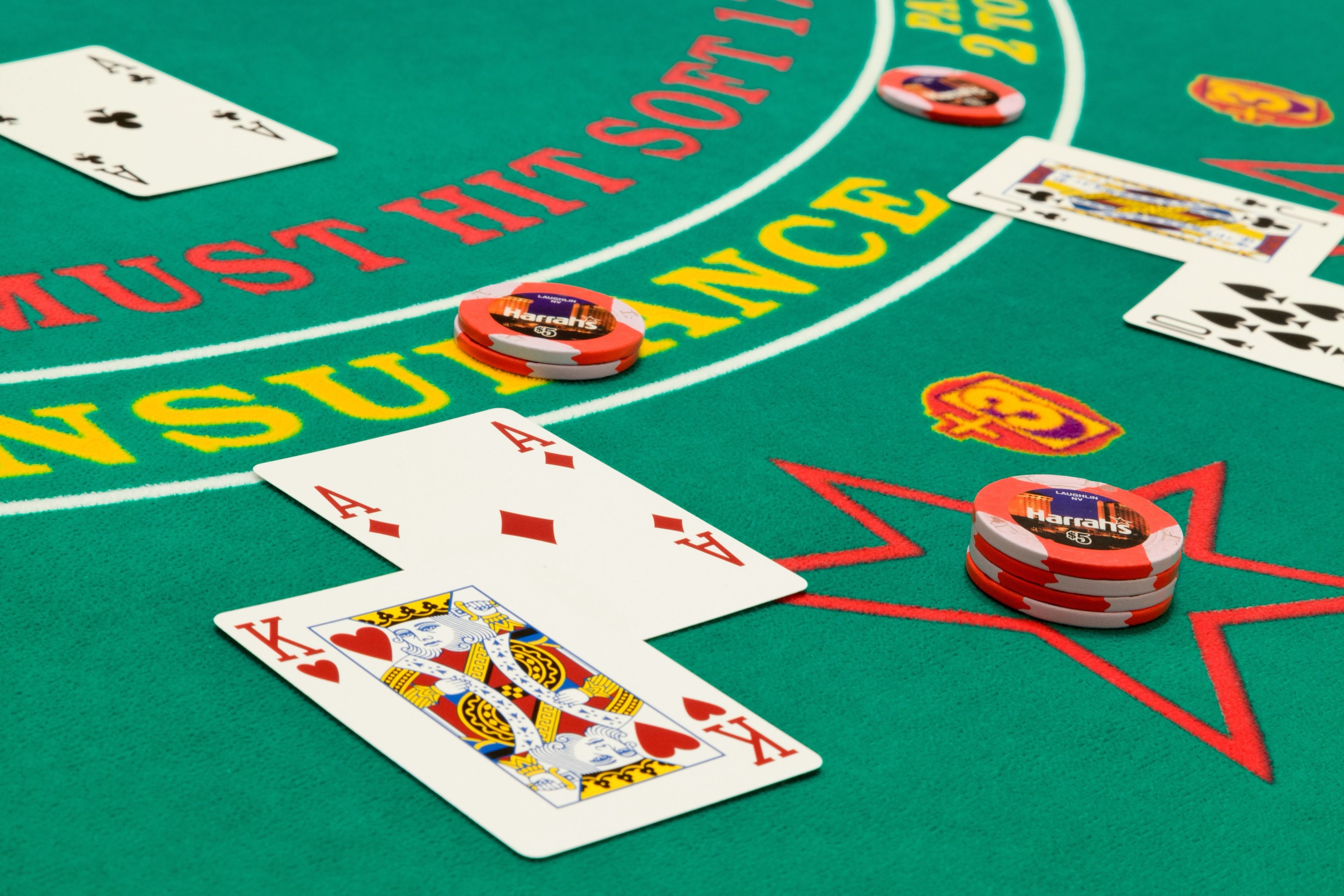 A green felt table with playing cards and poker chips.