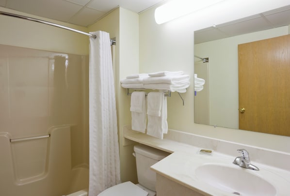 A bathroom with a shower, toilet, sink, and a mirror. - Paynesville Inn And Suites (Paynesville)
