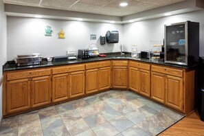 A modern kitchen with wooden cabinets, a granite countertop, and a built-in refrigerator.