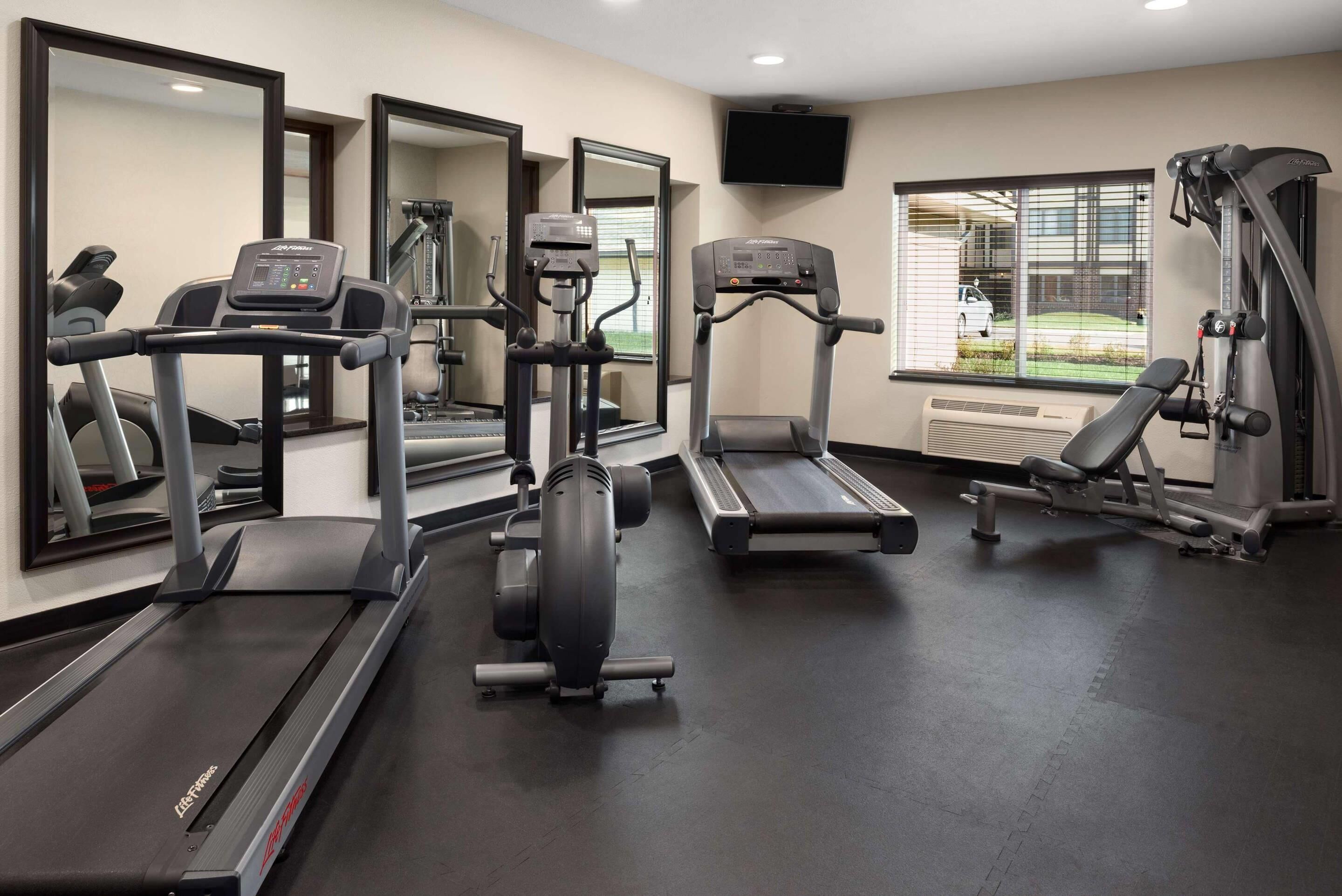 Academia com esteiras, elípticos e equipamentos de musculação.