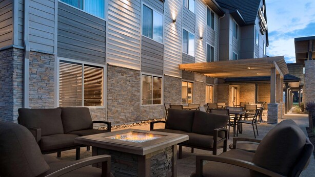 An outdoor patio area with a fire feature, seating, and a covered dining area. - Country Inn & Suites by Radisson, St. Cloud West, MN (St Cloud)