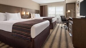 A hotel room with two beds, a desk, a chair, a TV, and a large window with curtains. - Country Inn & Suites by Radisson, St. Cloud West, MN (St Cloud)