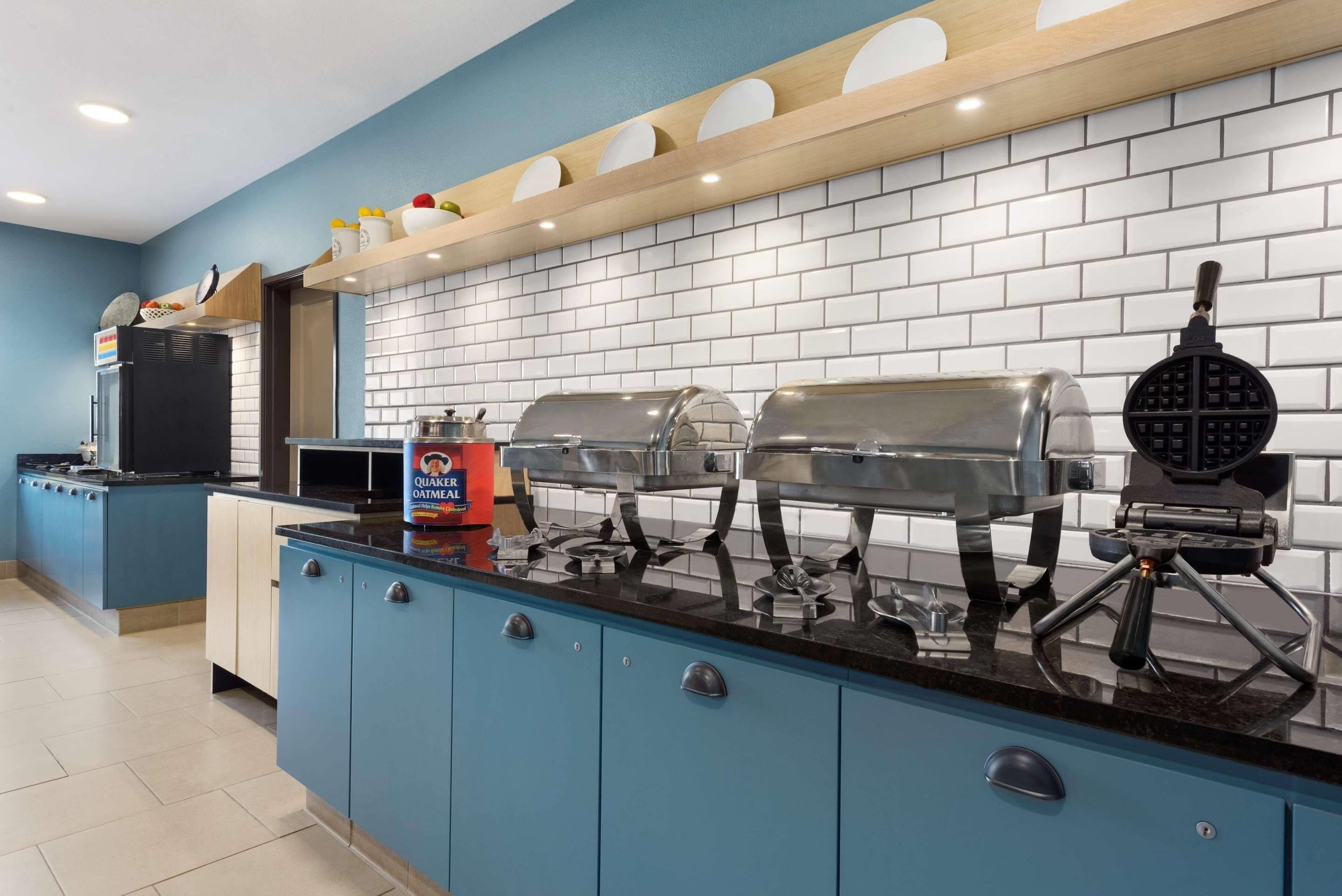 A breakfast bar with waffle makers, a coffee machine, and a sign for Quaker Oatmeal.
