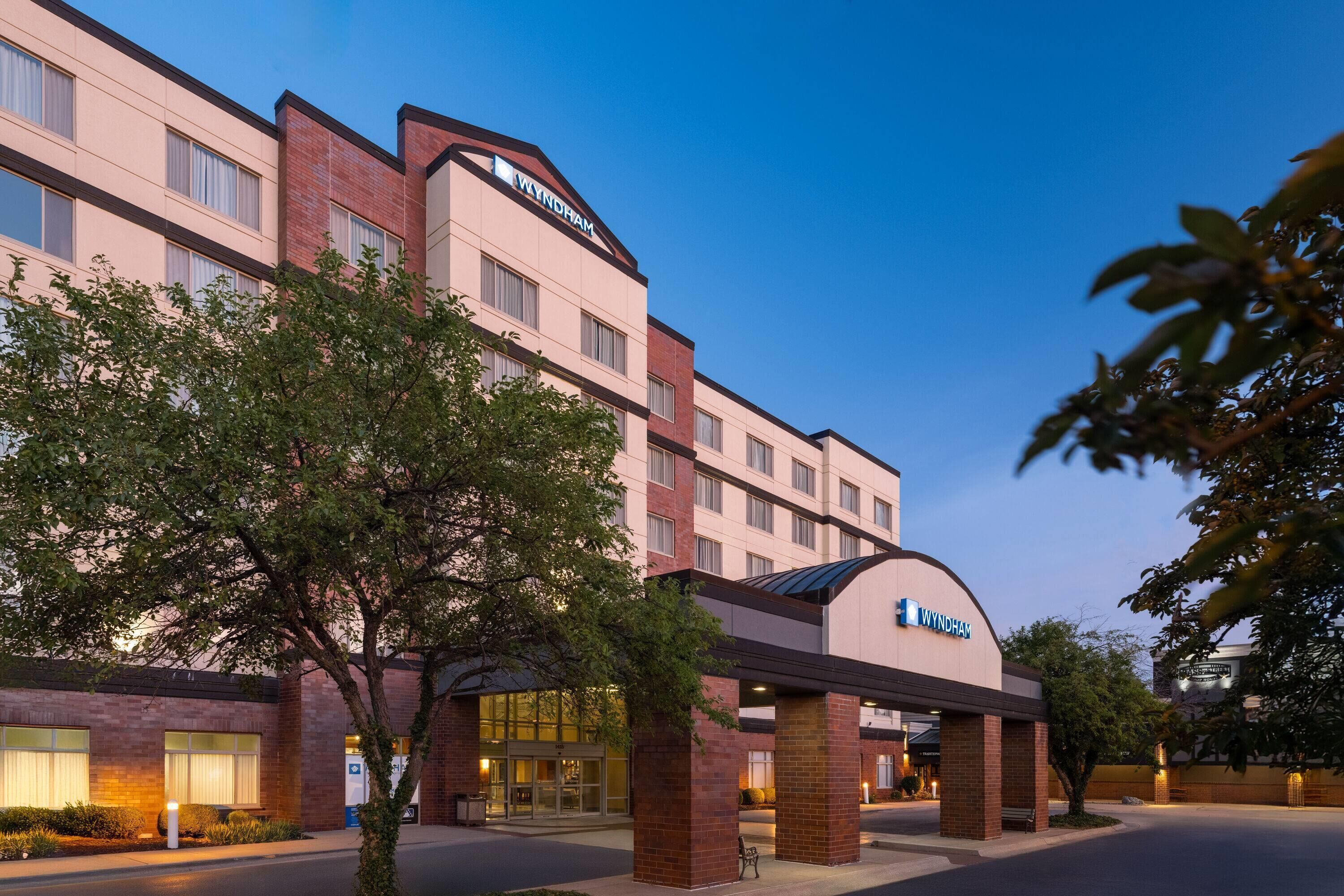 A Wyndham hotel with a modern facade, large windows, and a prominent entrance.
