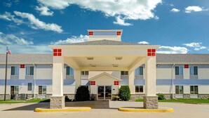 L’entrée d’un hôtel, avec un auvent, un drapeau et un ciel dégagé.