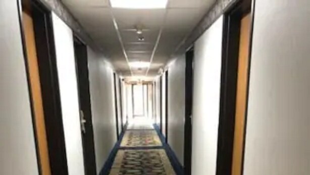 Een hotelgang met een kleurrijk tapijt met geometrische patronen.