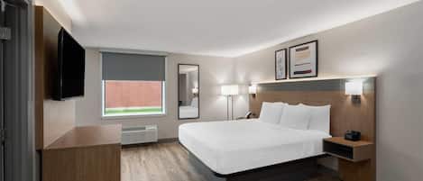 A modern hotel room with a large bed, bedside lamps, a flat-screen TV, and a window with a view.