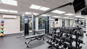 A gym with various exercise equipment, including dumbbells and a bench. - La Quinta Inn & Suites by Wyndham Goodlettsville - Nashville (Goodlettsville)