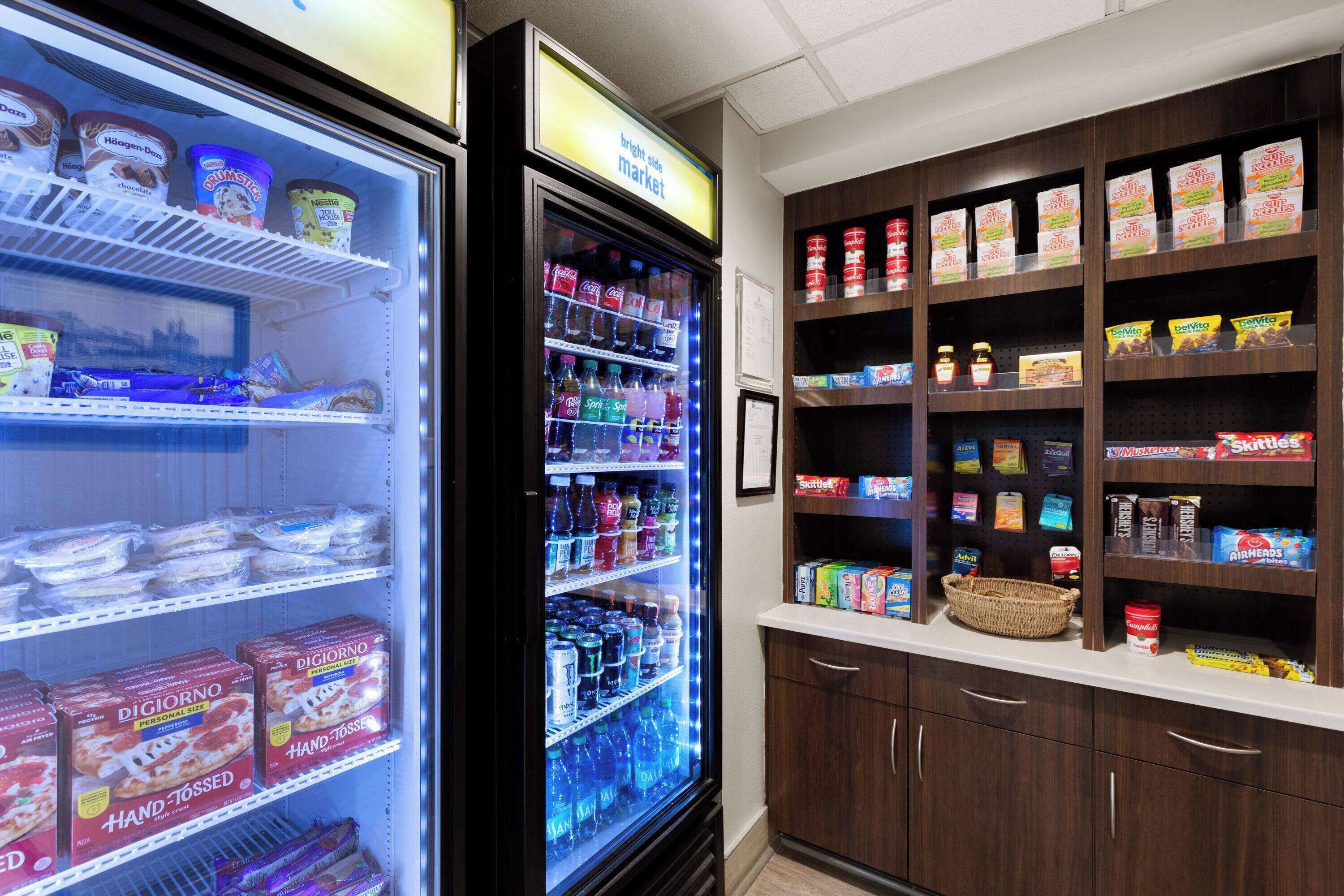 Mostrador refrigerado con diferentes productos alimenticios y bebidas, como helado y agua embotellada.