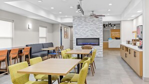 A modern hotel lobby with a reception desk, seating area, and a television screen. - Hampton Inn Akron-Fairlawn (Akron)