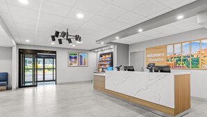 A modern reception area with a marble counter, a 'Welcome to Hampton' sign, and a snack shelf. - Hampton Inn Akron-Fairlawn (Akron)