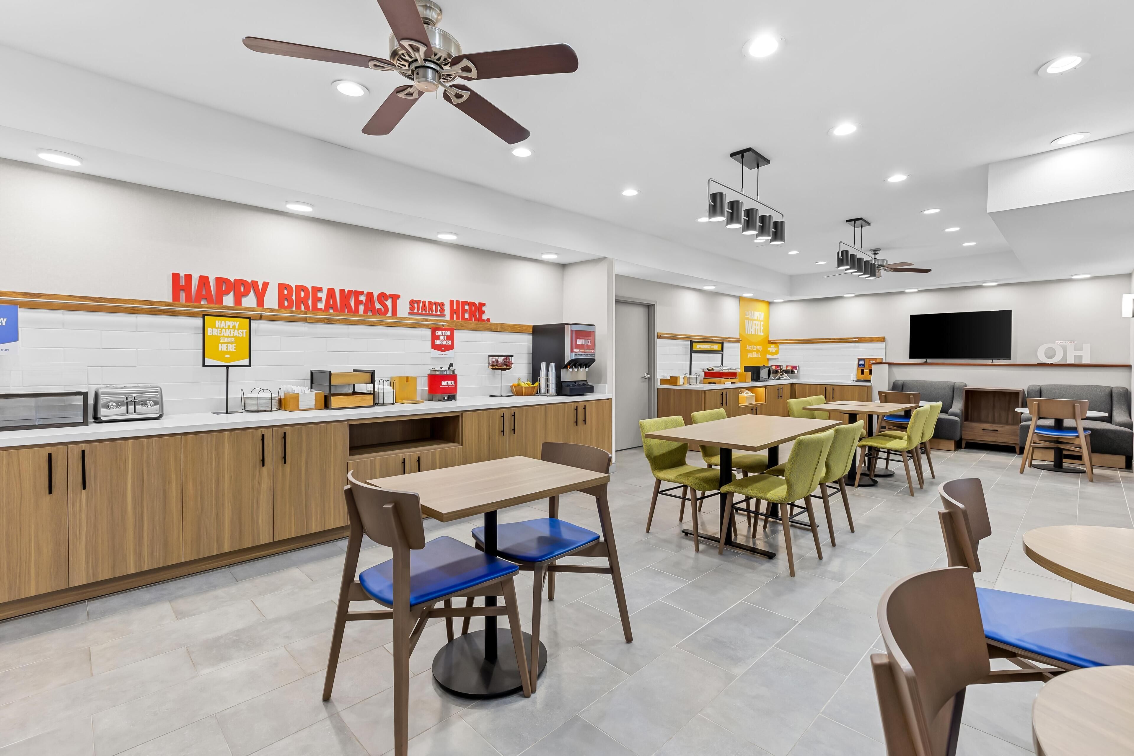 A modern breakfast area with wooden cabinets, a counter, and seating arrangements.
