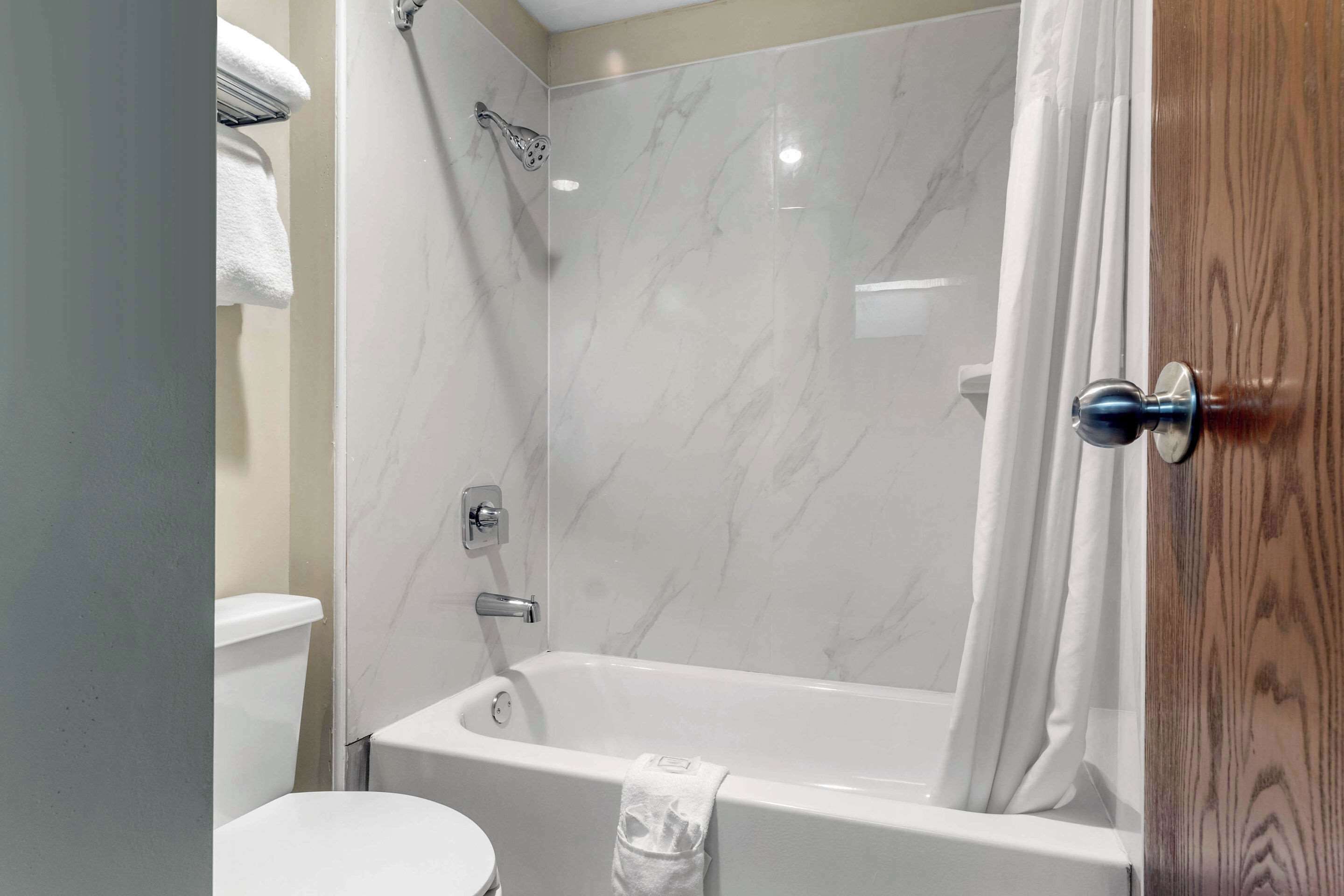 A bathroom with a bathtub, a toilet, and a shower.