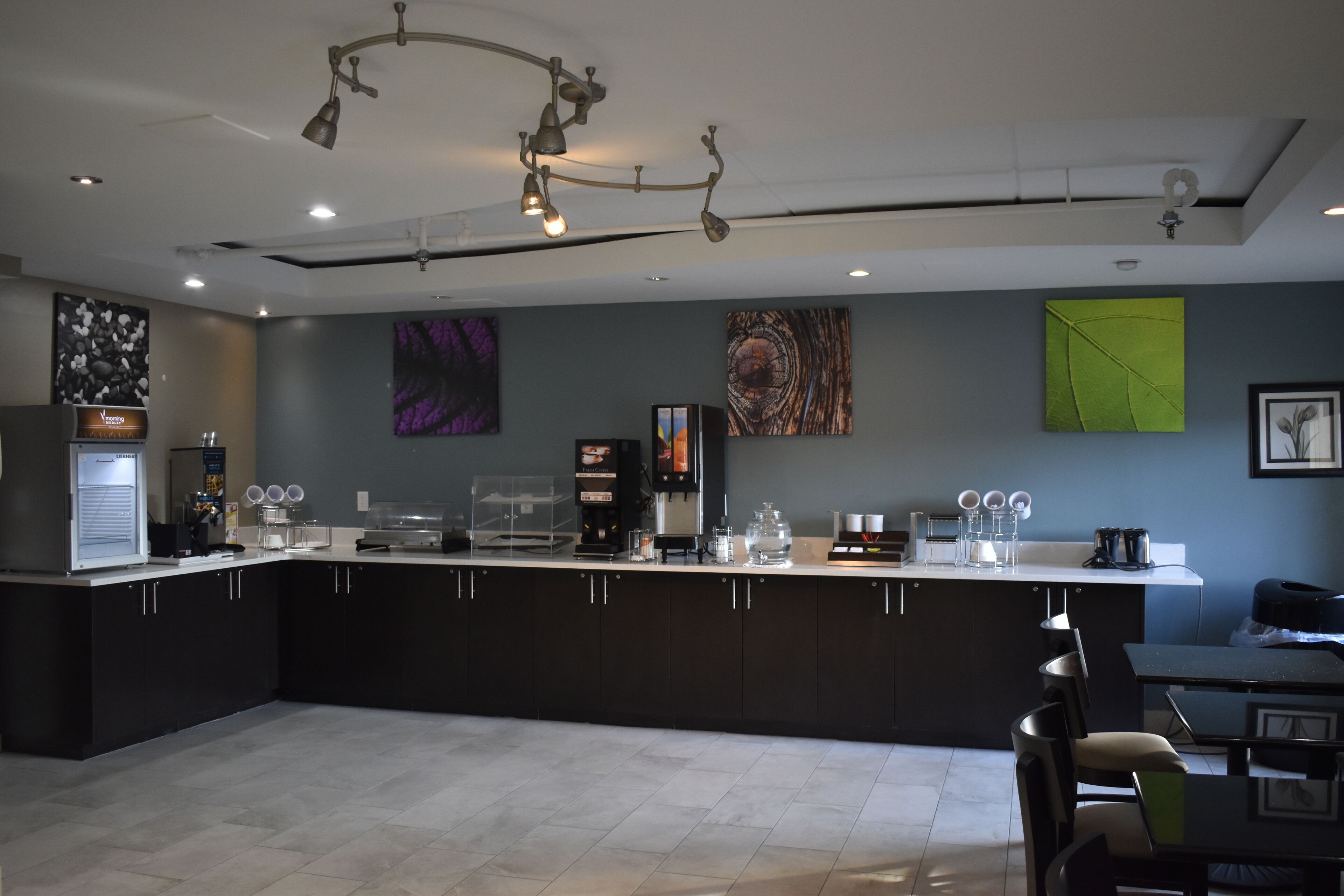 Una cocina moderna con una isla central, equipada con cafetera, estación de té y cristalería.