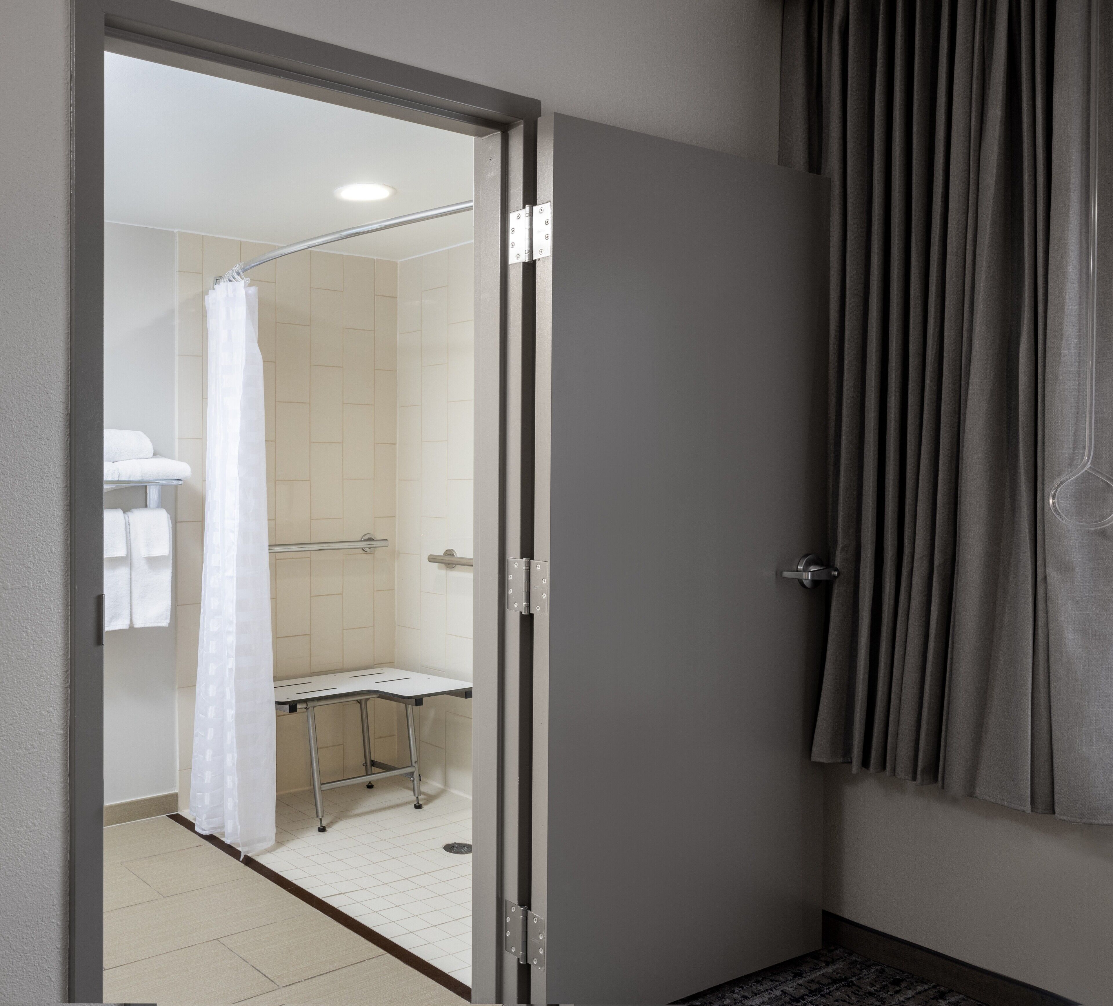 A bathroom with a shower, a toilet, and a towel rack.