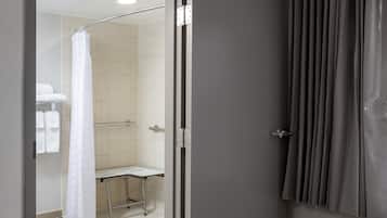 Een badkamer met een douche, toilet en handdoekhouder.