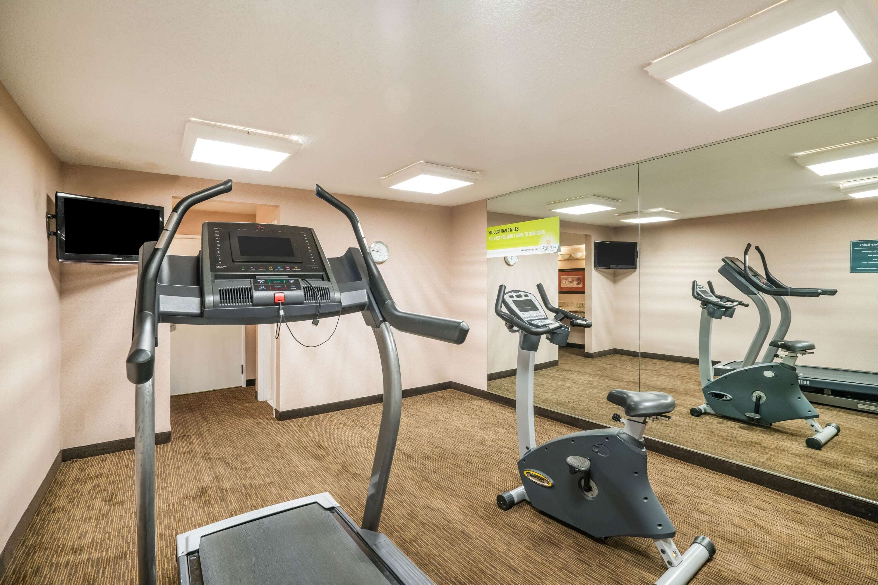A gym with treadmills, an elliptical, and a stationary bike.