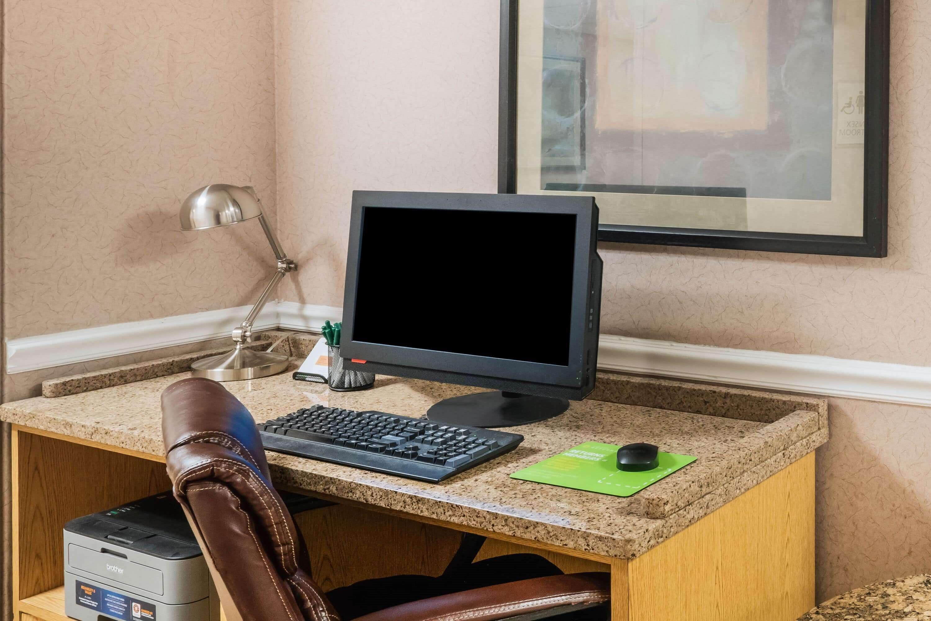 A workspace with a computer, keyboard, mouse, and a printer.