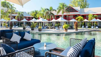 Relax by the pool surrounded by lush greenery and comfortable lounge chairs.