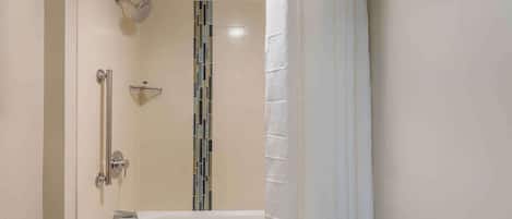 A modern bathroom with a bathtub, shower, and a towel rack.