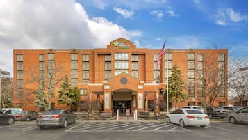 Stay America premier suites hotel features a central entrance with a clear view of the parking lot.