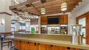 A modern kitchen with wooden cabinets, a stainless steel sink, and a coffee machine.