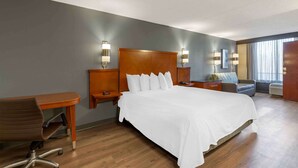 A hotel room with a large bed, a desk, a chair, and two bedside tables with lamps. - Extended Stay America Premier Suites - Cleveland - Independence (Independence)