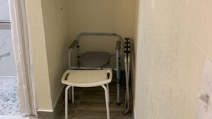 A small, enclosed bathroom with a toilet, a sink, and a shower area. - Days Inn by Wyndham Okmulgee (Okmulgee)