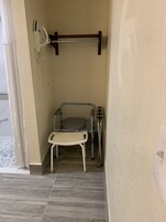 Un baño pequeño y cerrado con inodoro, lavamanos y zona de ducha.