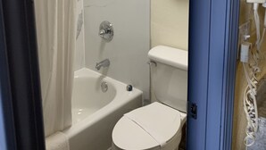A bathroom with a shower, bathtub, toilet, and a towel rack. - Days Inn by Wyndham Okmulgee (Okmulgee)