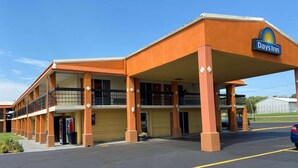 A Days Inn with a two-story structure, a covered parking area, and a visible Pepsi vending machine. - Days Inn by Wyndham Okmulgee (Okmulgee)