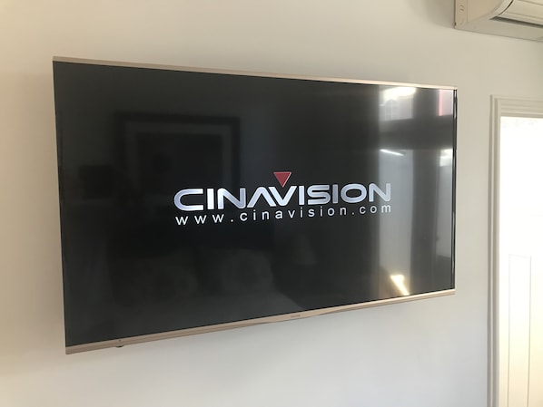 A flat-screen TV mounted on a wall with the logo "CINAVISION" and website "www.cinavision.com". - Art Hotel on York (Launceston)