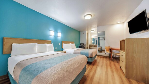 A hotel room with two beds, a desk, a chair, a TV, and a wardrobe. - Motel 6 Canby, OR (Canby)