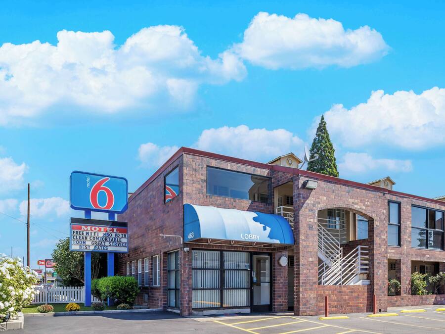 A motel with a brick facade, a large sign, and a visible entrance.