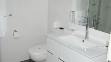 Habitación Deluxe, 1 cama Queen size | Baño | Regadera, amenidades de baño gratuitas, secadora de cabello, toallas