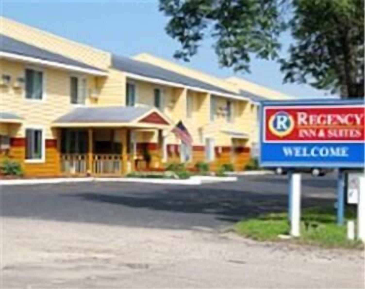Punavalkoinen kyltti ilmoittaa: «Regency Inn & Suites – lämpimästi tervetuloa». Kyseessä on kaksikerroksinen motelli.