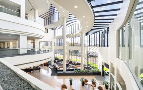 A multi-level atrium with open spaces, seating areas, and a central garden.