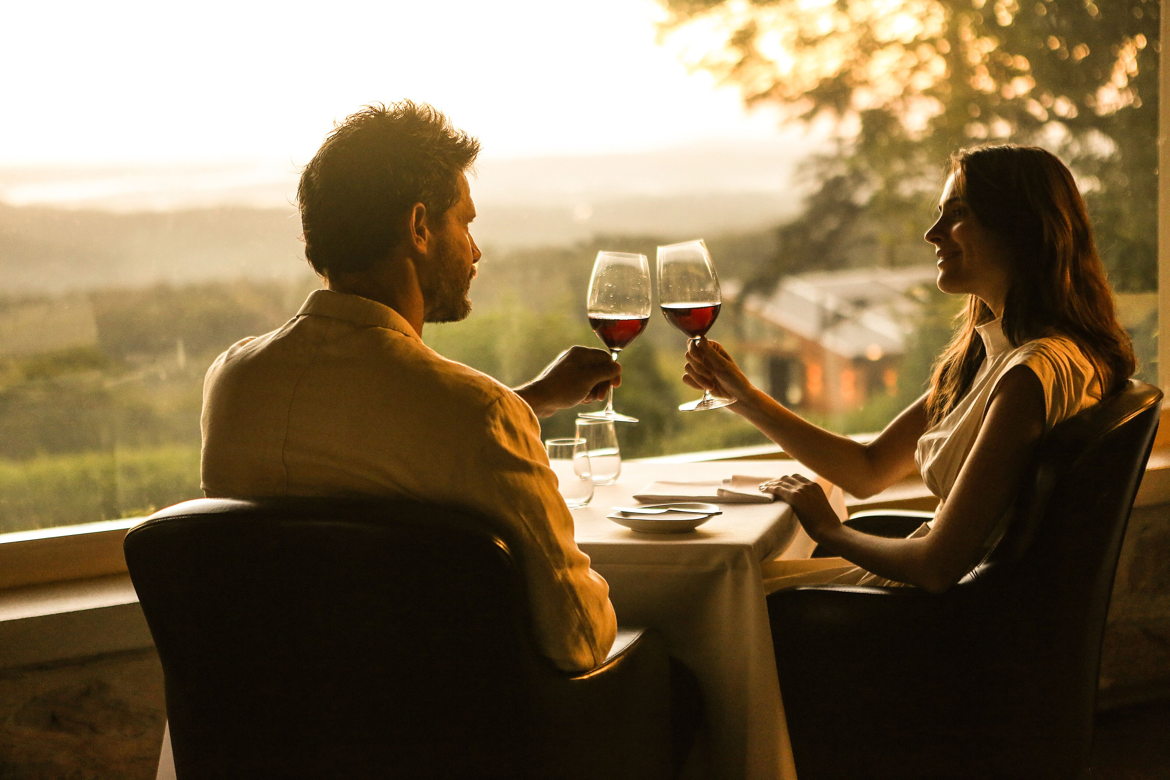 Un couple est assis à une table, devant un paysage.