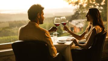 Un couple est assis à une table, devant un paysage.