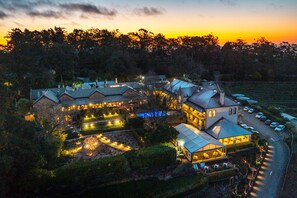 A large, multi-story hotel with a central courtyard, surrounded by lush greenery and a parking area. - Mount Lofty House & Estate Adelaide Hills - Adults Retreat (Crafers)