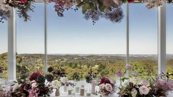 Ein Tisch, gedeckt mit Blumen und Kerzen, mit Blick auf eine malerische Landschaft.