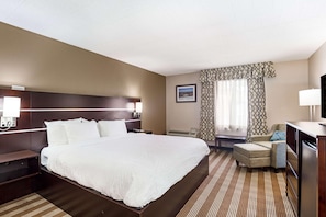 A hotel room with a large bed, bedside tables, a desk, a chair, and a television. - Pocono Inn at Water Gap (Delaware Water Gap)