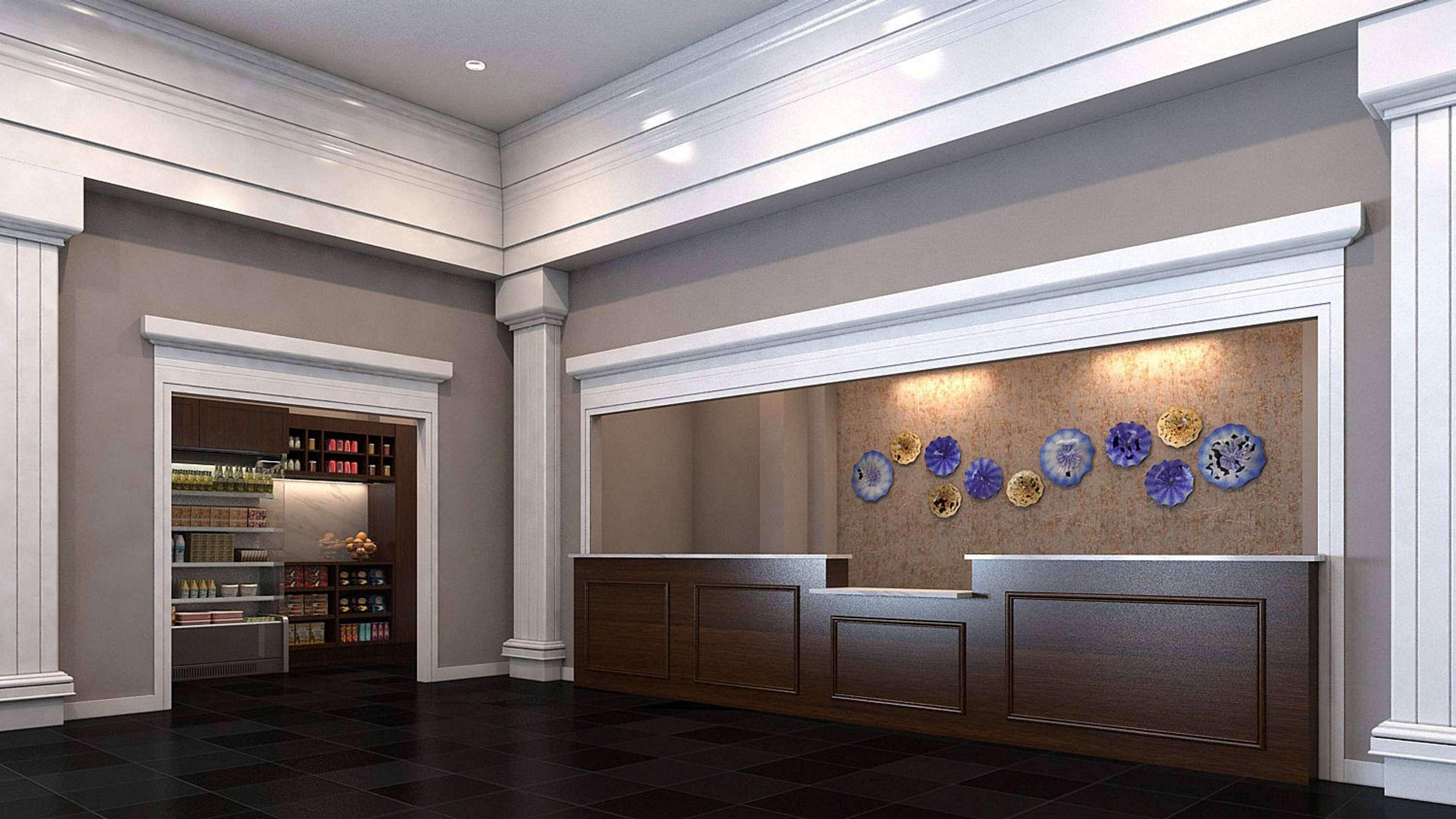 A reception area with a dark wood reception desk, a wall-mounted display of decorative plates, and a shelving unit with various items.