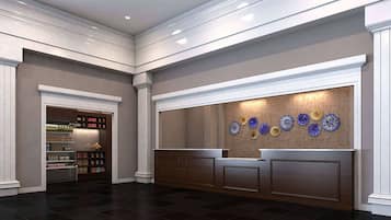 A reception area with a dark wood reception desk, a wall-mounted display of decorative plates, and a shelving unit with various items.
