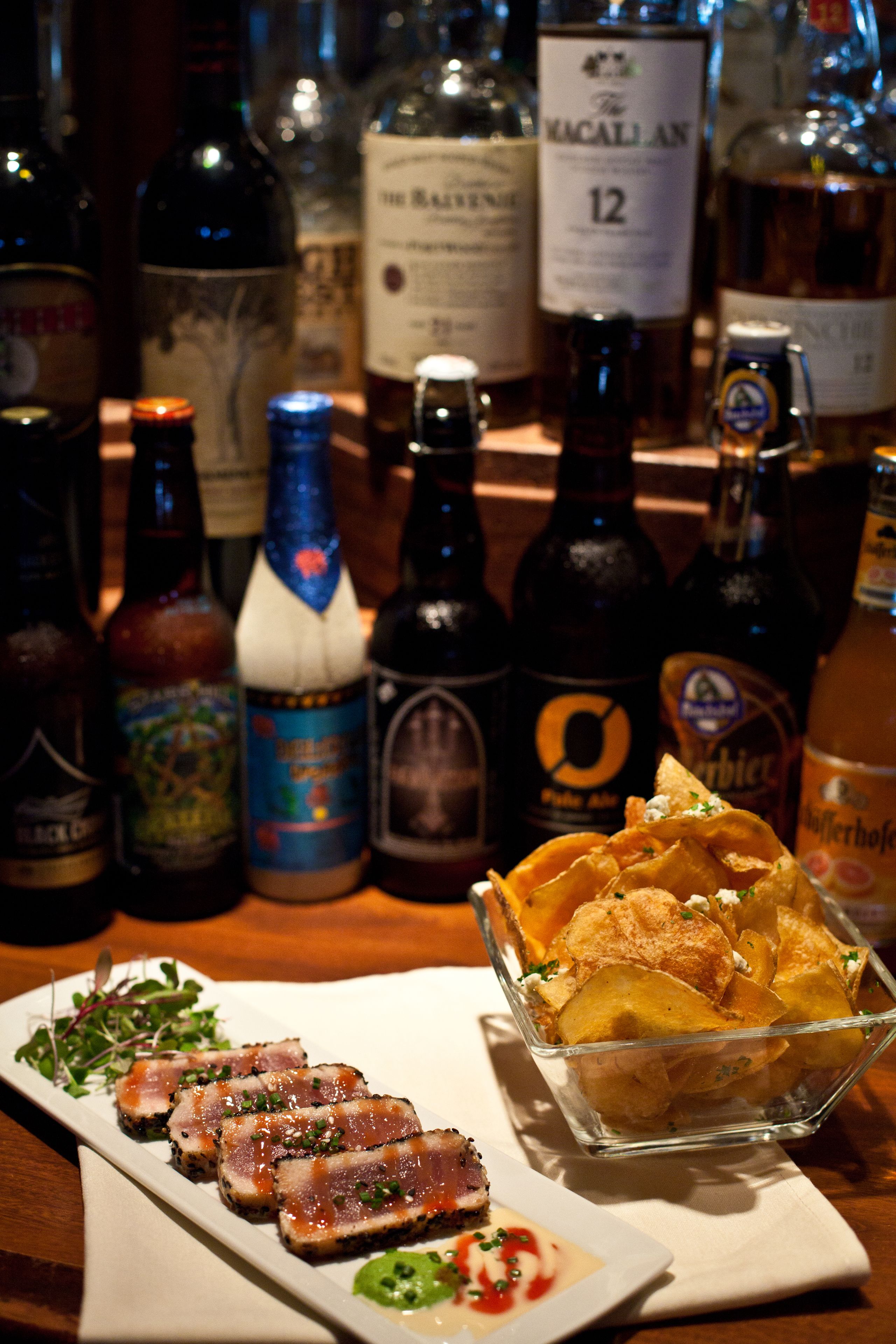 Un bar con diferentes botellas de alcohol y un plato de comida.