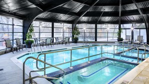 An indoor swimming pool with a tiled edge, a no diving sign, and chairs around the pool. - Desmond Hotel Malvern, a DoubleTree by Hilton (Malvern)