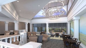 A spacious lobby with a high ceiling, a large chandelier, and a view of the outdoors through expansive windows. - Desmond Hotel Malvern, a DoubleTree by Hilton (Malvern)